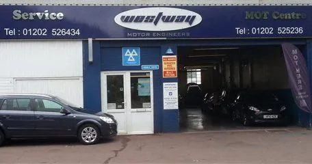 The front of West Way Motor Engineers on Wimborne Road, with the westway sign above the workshop doors and cars in the bays.